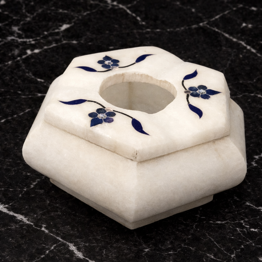 Hexagon marble cigar ashtray with blue inlay on dark marble surface