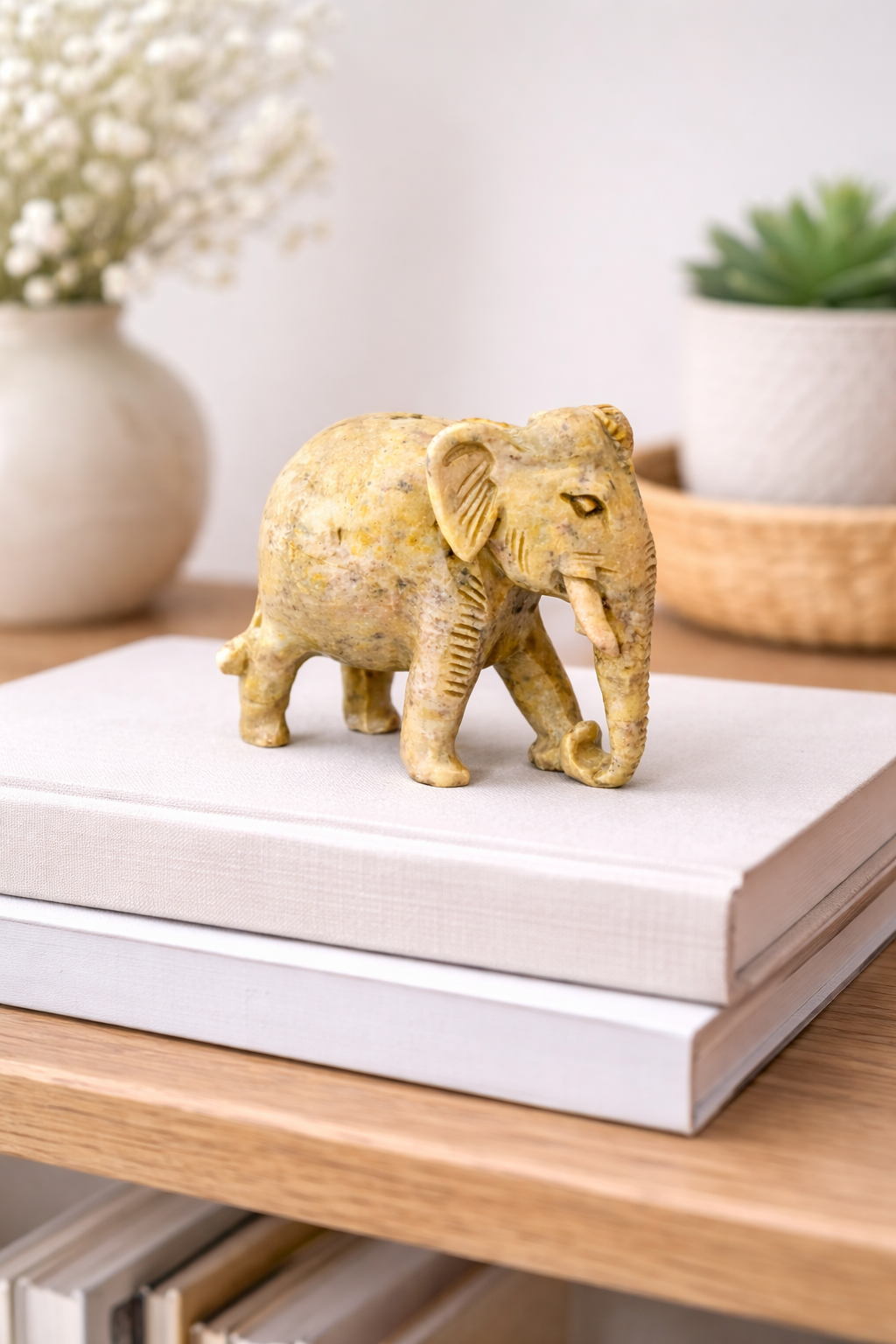 0.234 kg Hand-carved polished stone elephant figurine placed on stacked books as decorative bookshelf decor.
