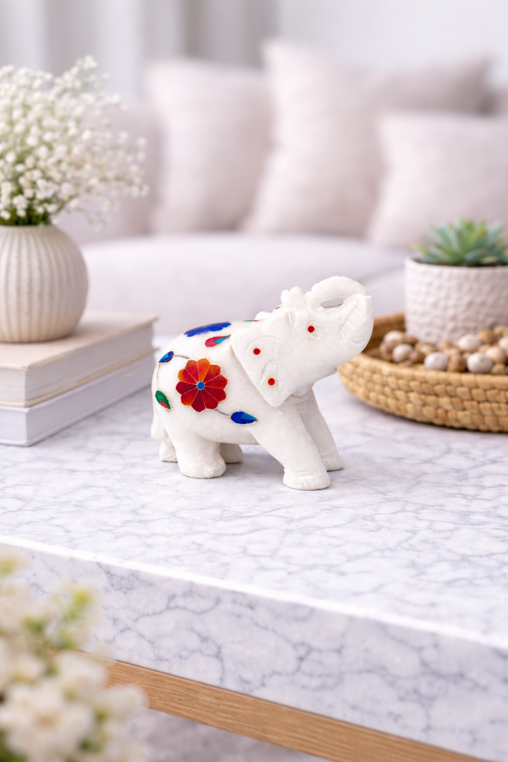 Luxury white marble elephant figurine with colourful floral inlay used as desk décor.