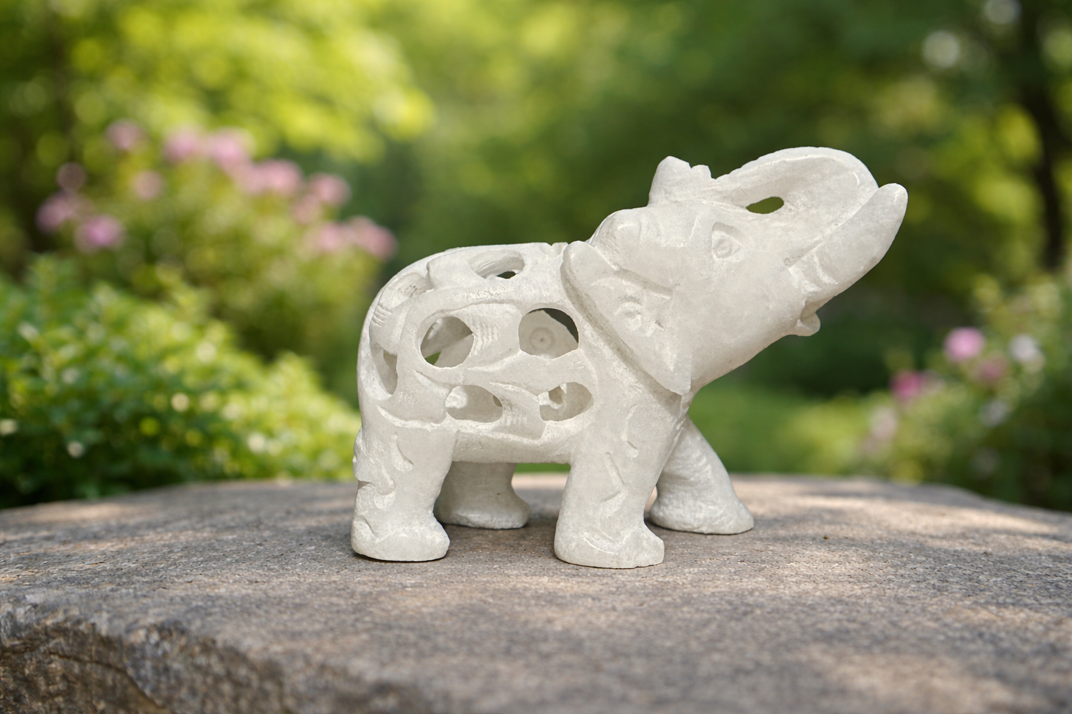 hand carved white marble elephant sculpture elephant within elephant design on stone surface outdoors