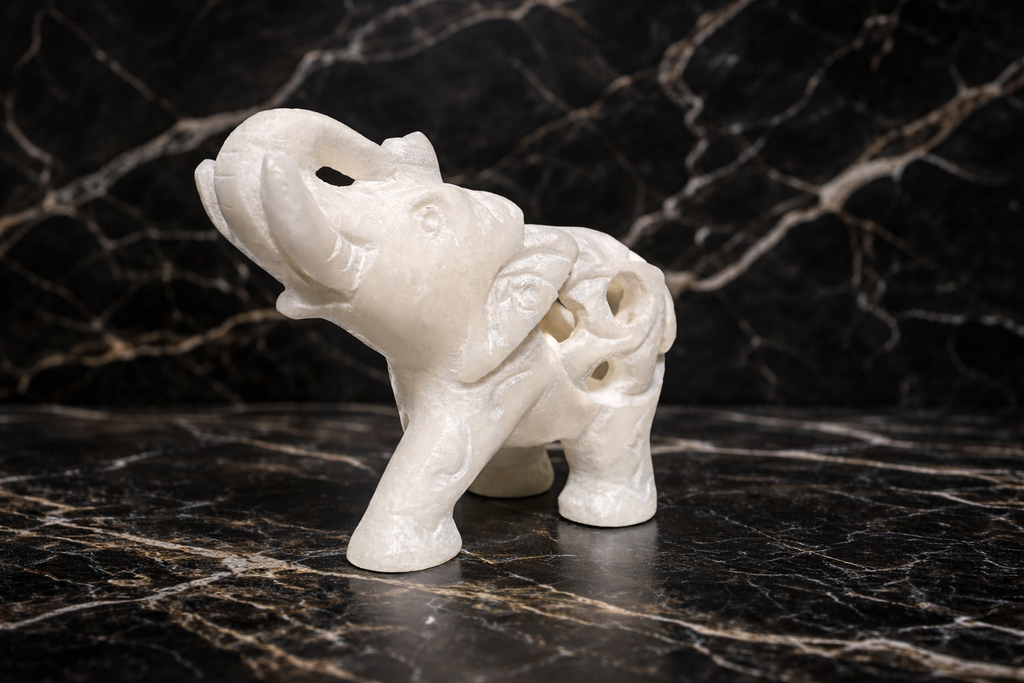 0.313 kg intricate white marble elephant sculpture with elephant inside carving on black marble surface