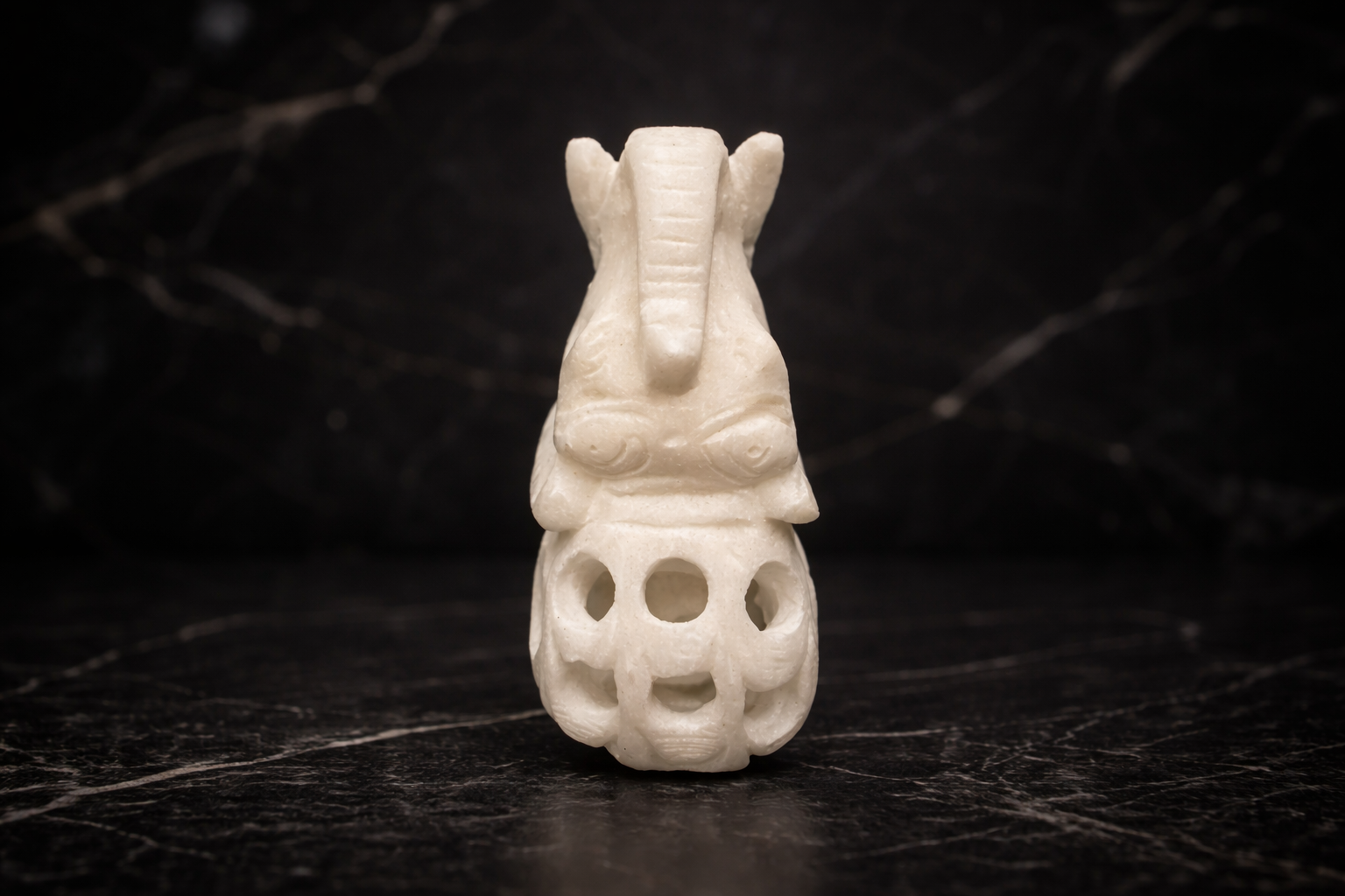 Top view of decorative marble elephant figurine elephant inside elephant design on black surface