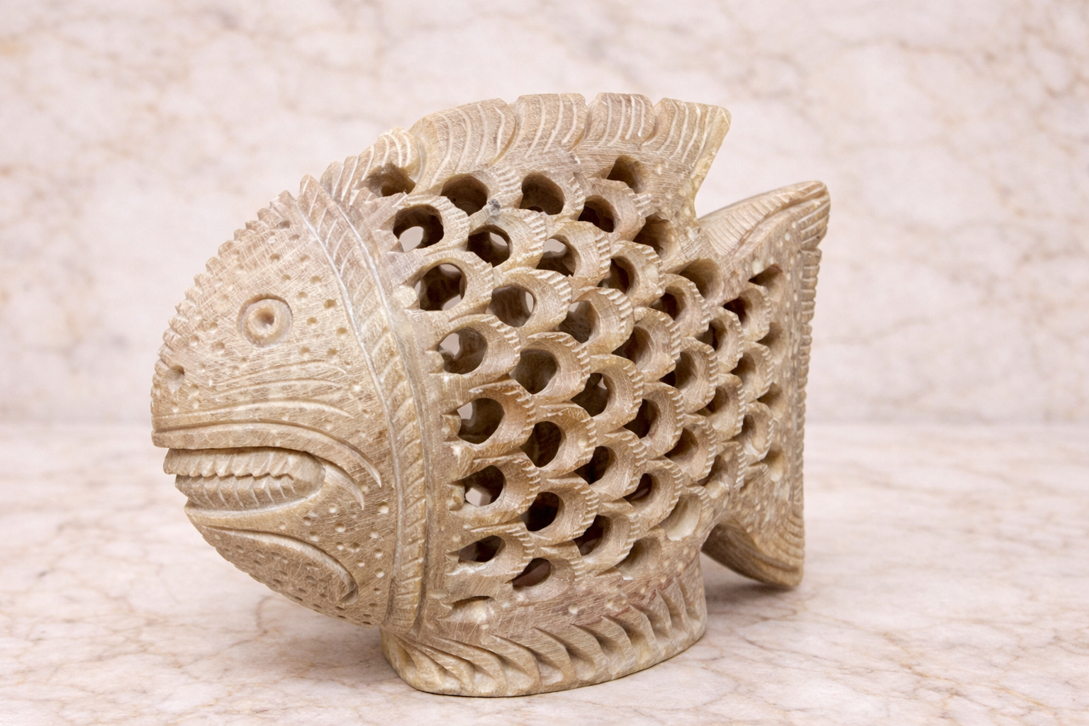 Hand-carved soapstone fish sculpture with intricate lattice detailing, natural beige stone decorative home NZ