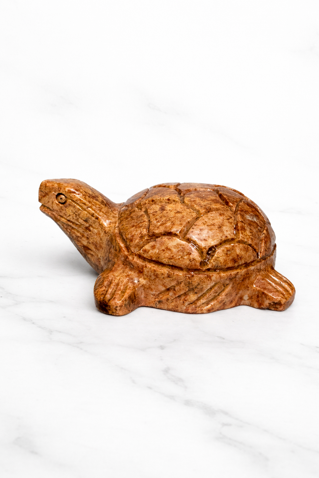 0.183 kg Hand-carved polished soapstone turtle sculpture on white marble surface