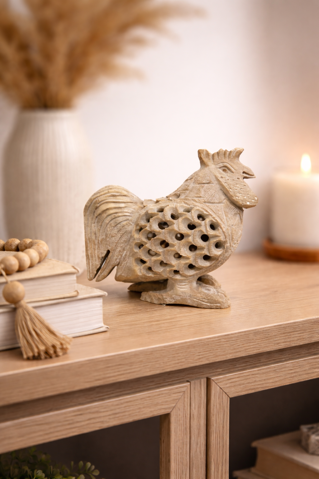 Soapstone rooster figurine with openwork carving displayed on wooden console with decor