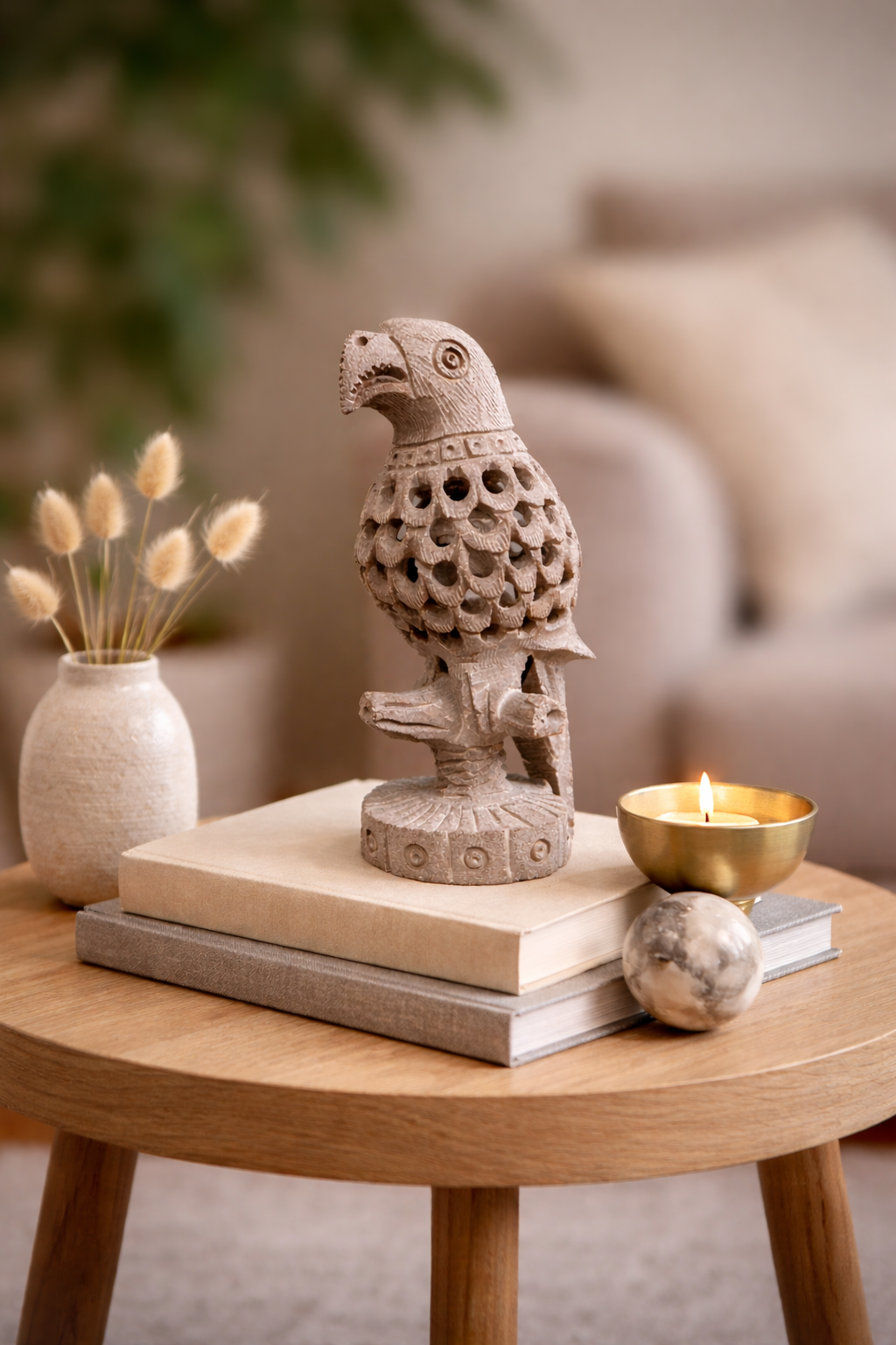 Hand-carved soapstone parrot sculpture styled on books with candle in modern NZ home setting