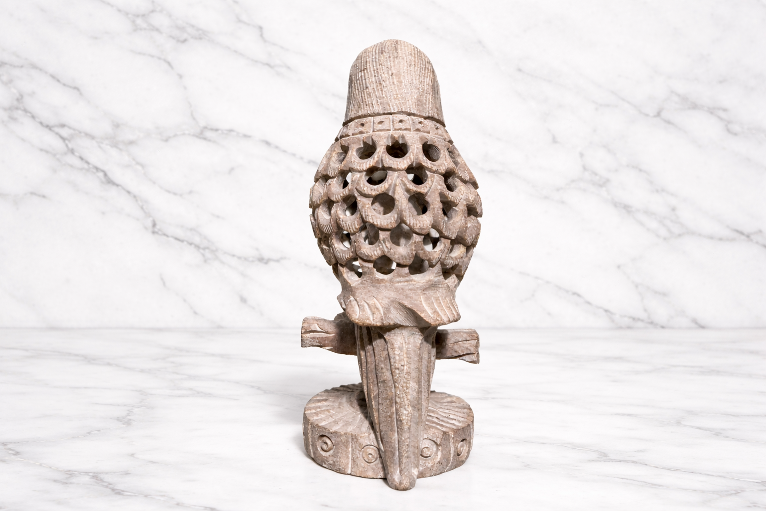  Rare view of Hand-carved soapstone parrot sculpture with intricate openwork feather design on marble background
