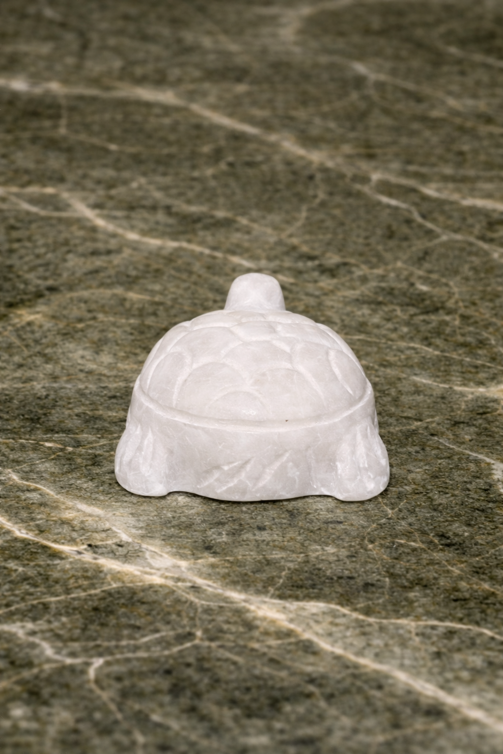 Rare view of Hand-carved white marble mini turtle decorative figurine on dark marble background