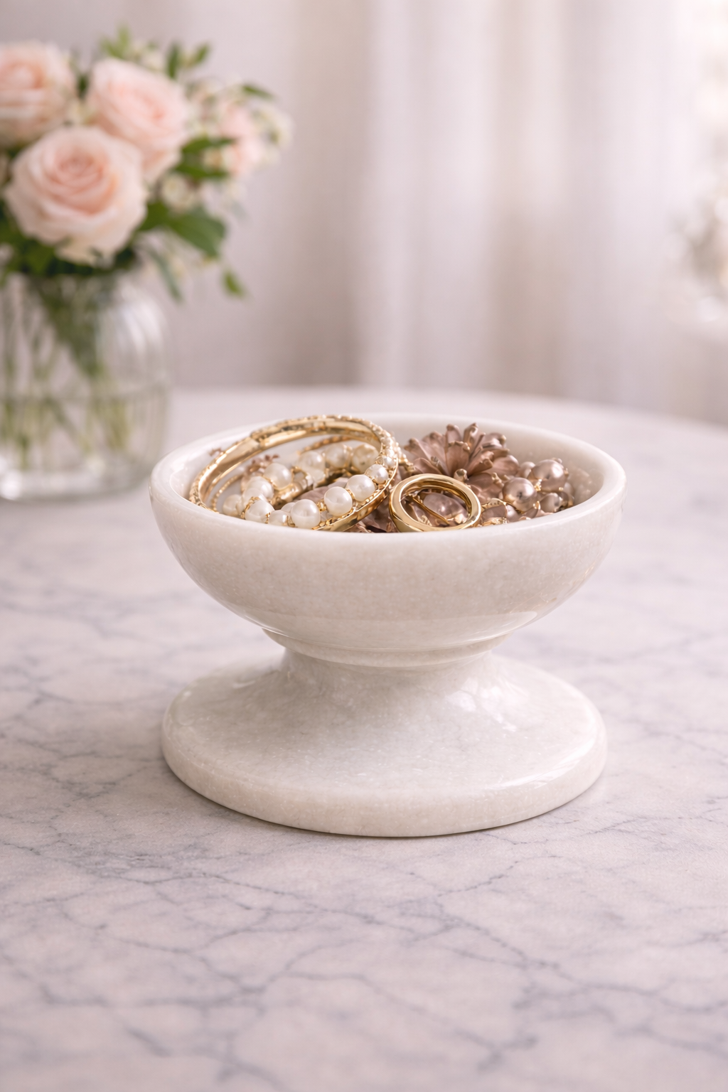 White marble pedestal bowl used as jewellery dish for rings and earrings