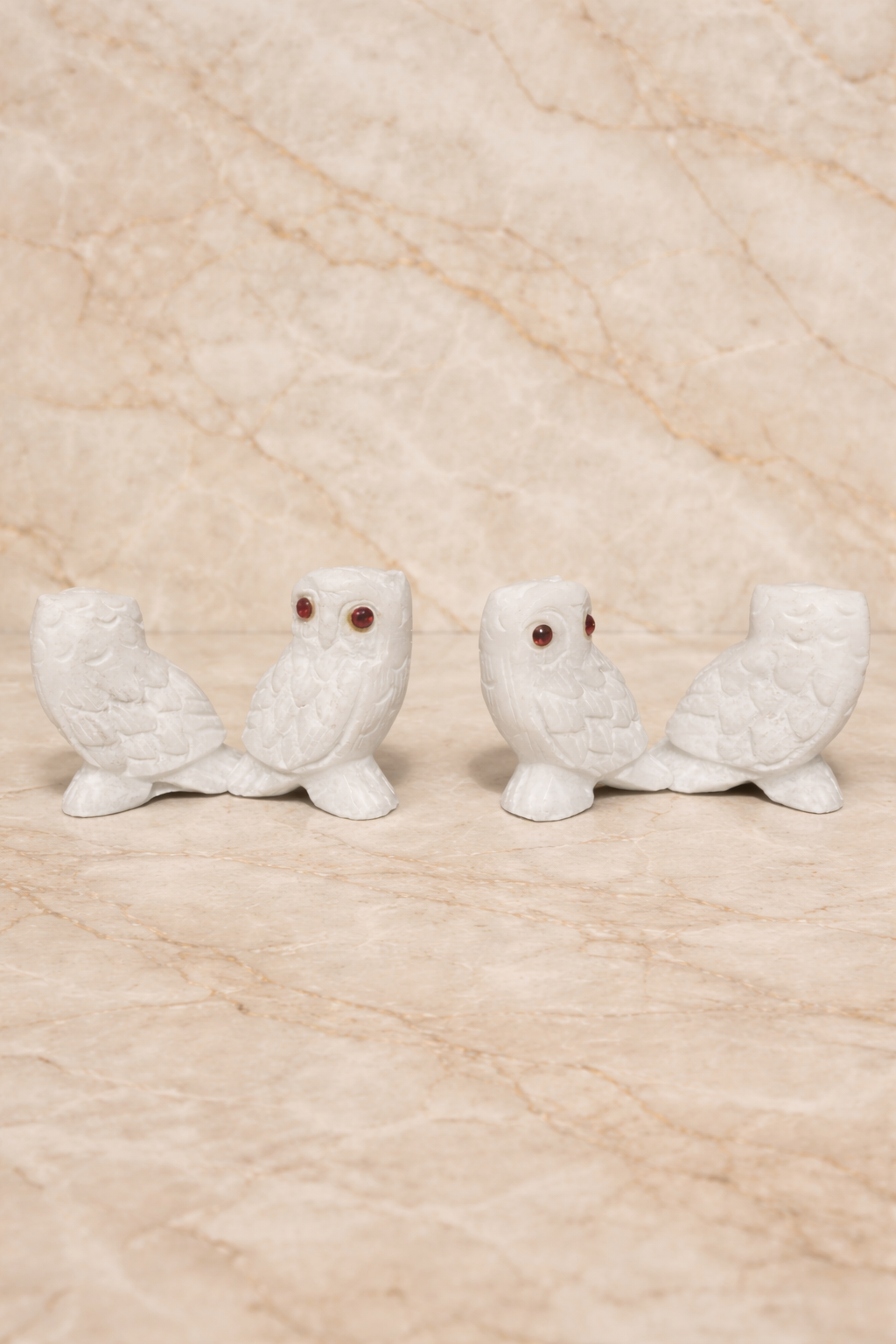 White marble owl figurine light set with red stone eyes styled on marble tabletop