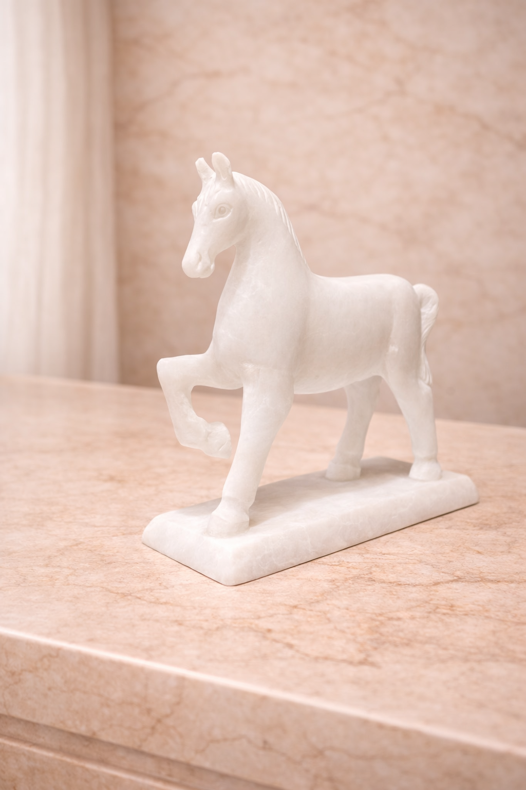 Side view of white marble horse sculpture on stand displayed on marble console table