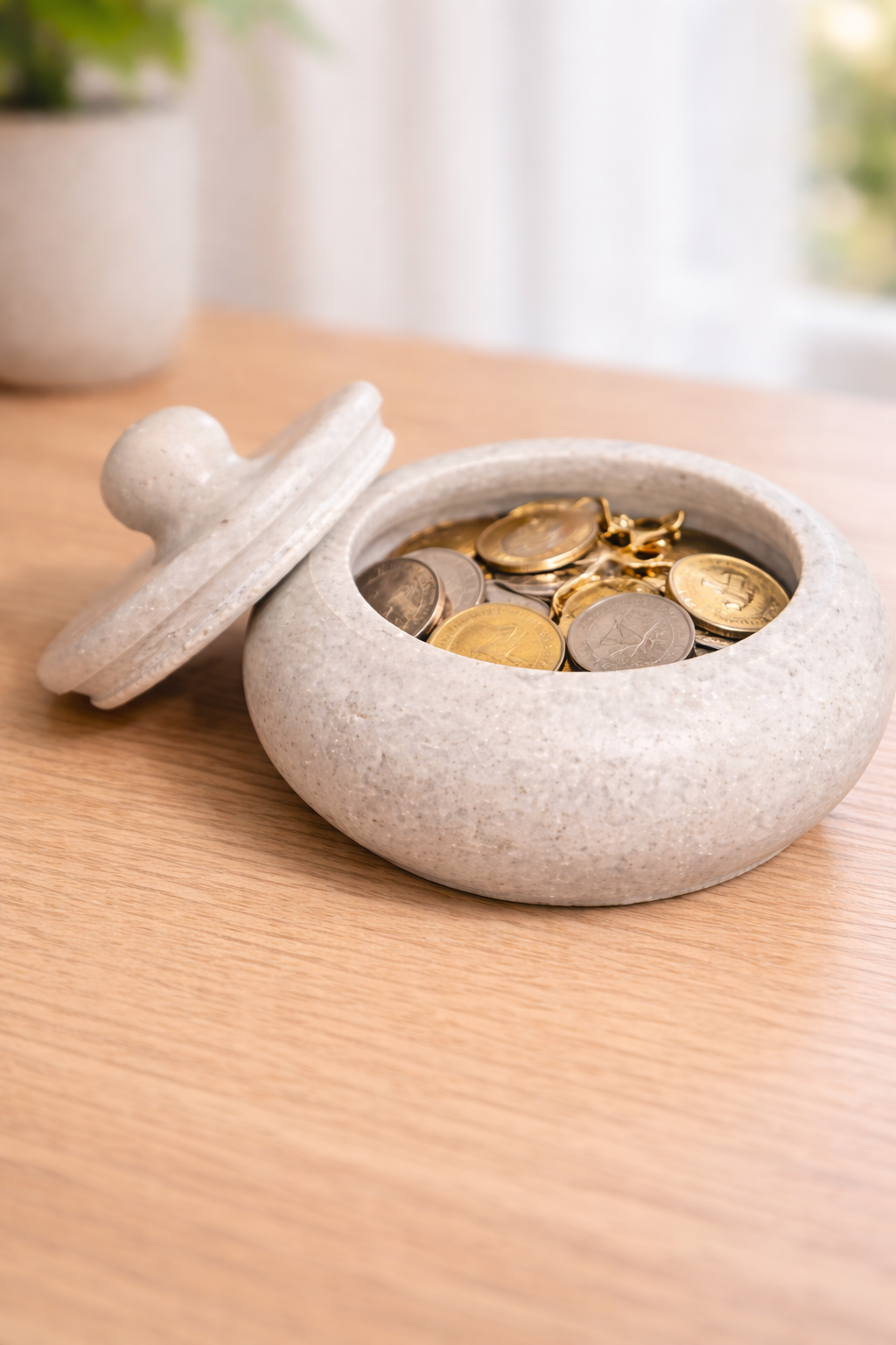 Small white marble bowl with lid for keys and coins displayed on entryway table