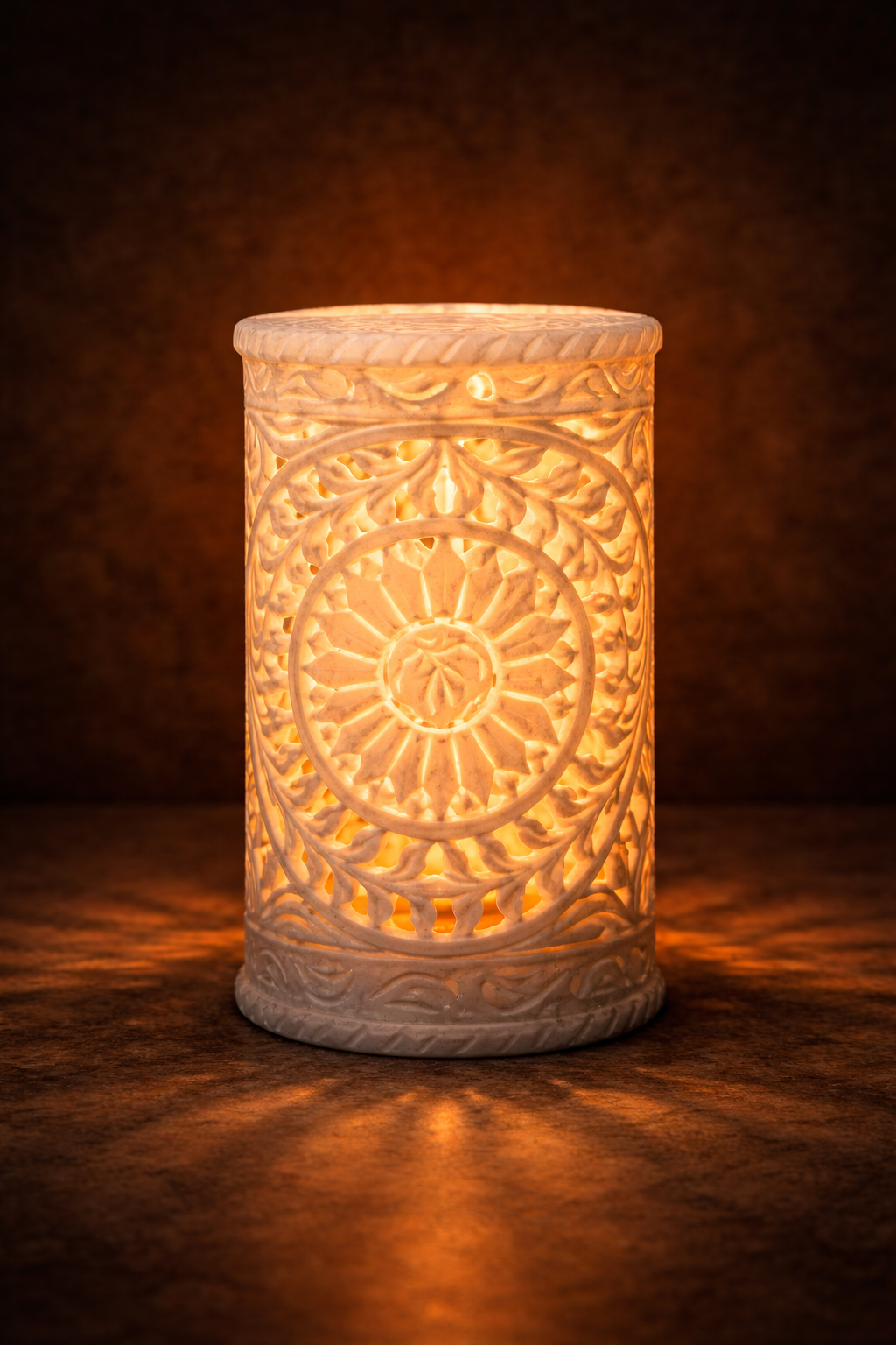 Hand-carved white marble candle holder glowing with warm light on dark background
