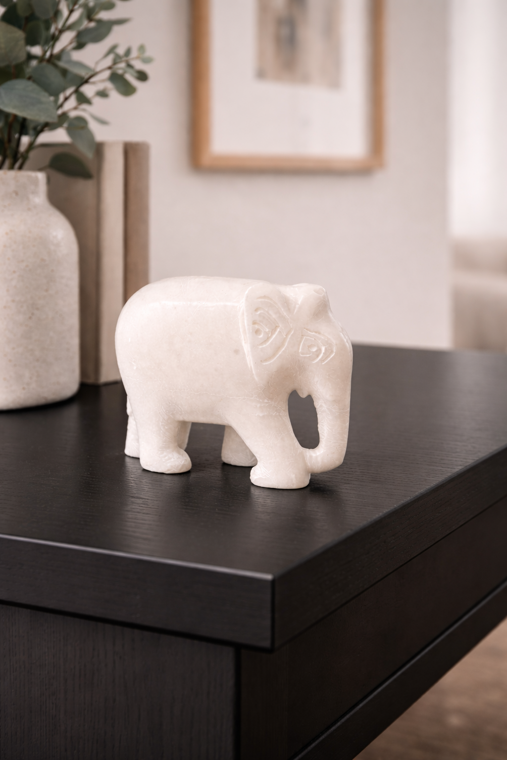 0.412 kg Polished white marble elephant sculpture on black marble table