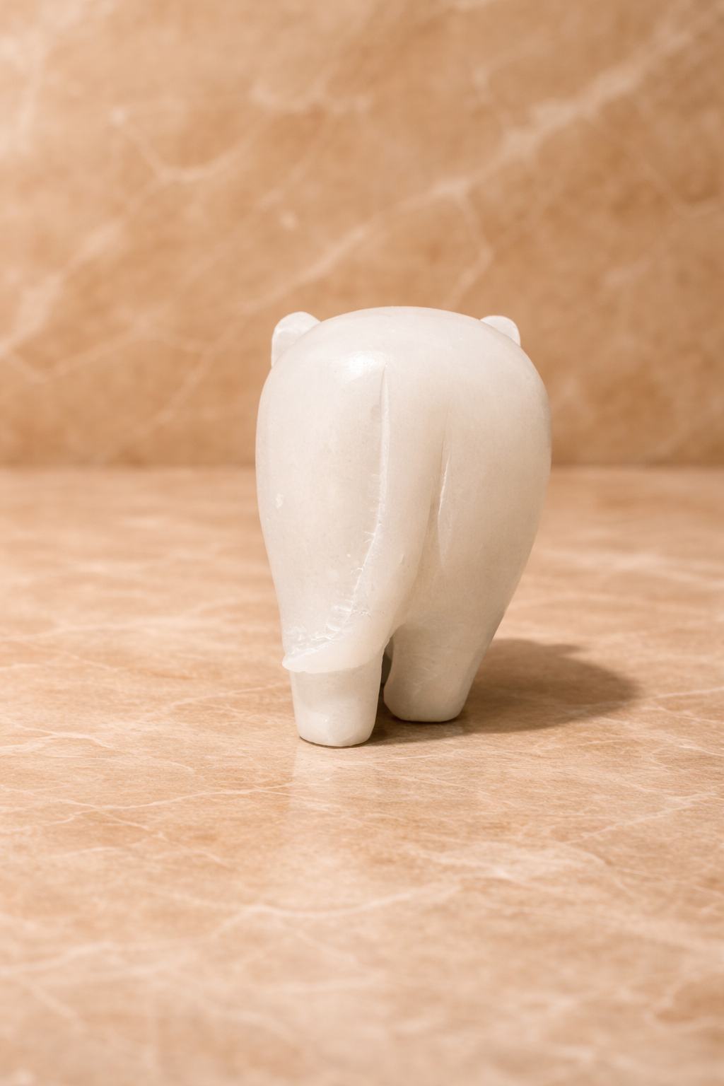 Rereview of polished white marble elephant sculpture on beige marble surface