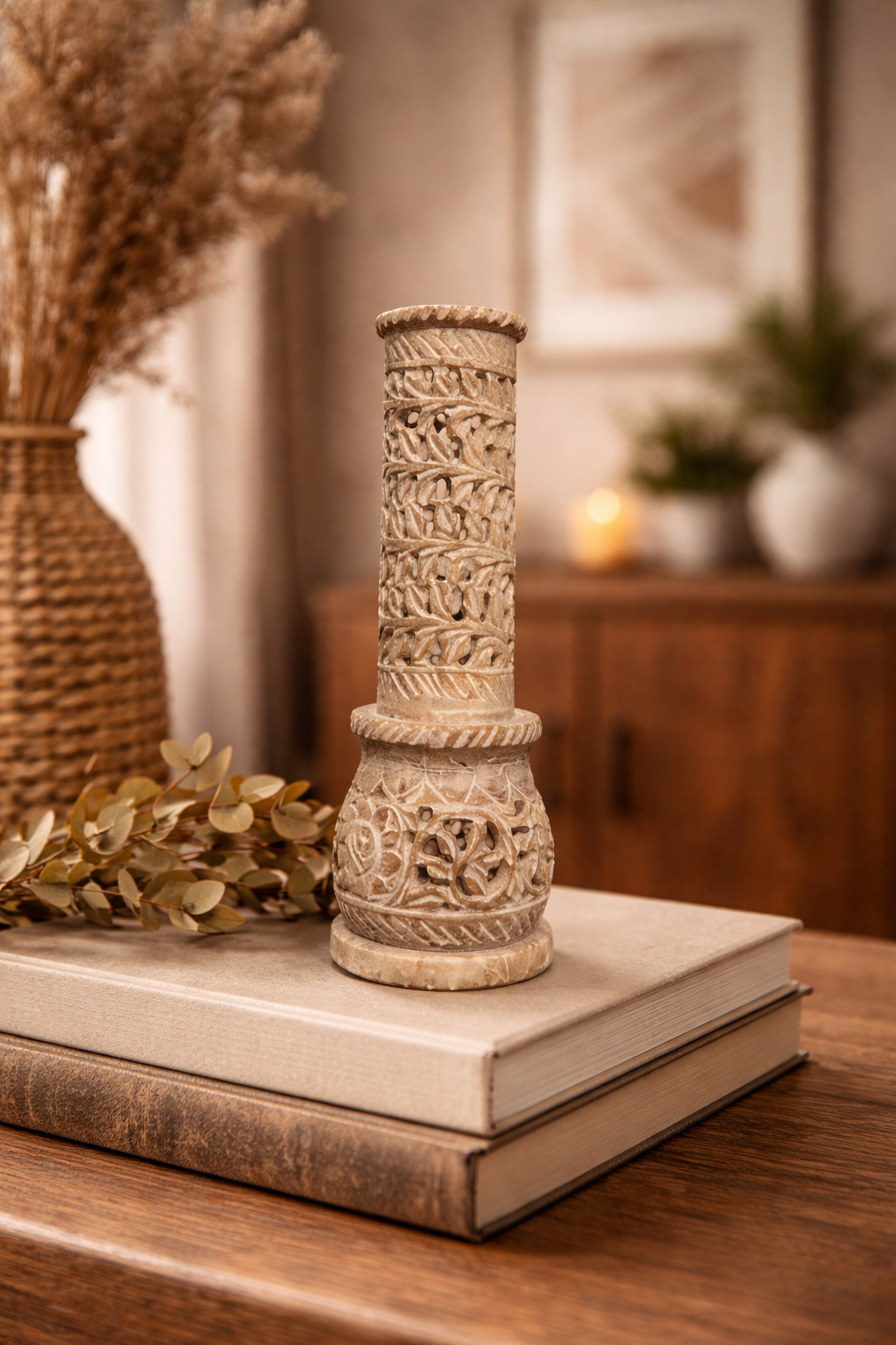 Soapstone incense burner tower with carved cut-outs on rustic wooden surface