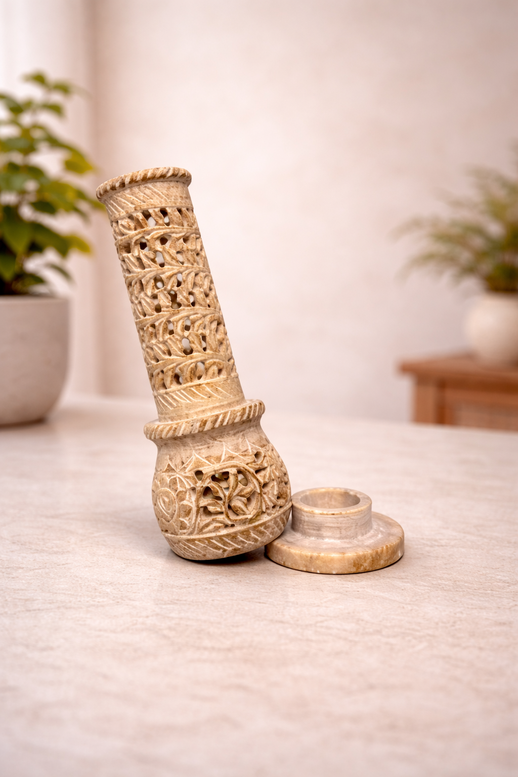 Soapstone incense burner tower with intricate carving on white marble background