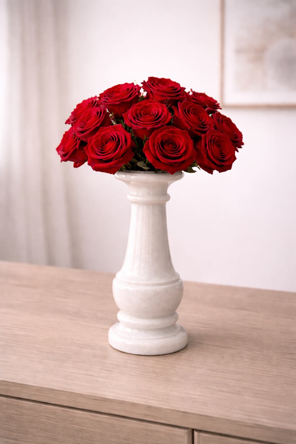 White marble vase with red roses on a wooden table