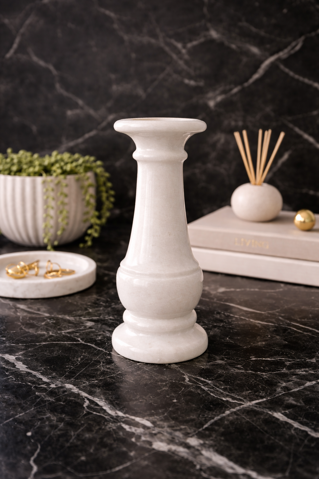 Solid white marble vase on a dark marble surface