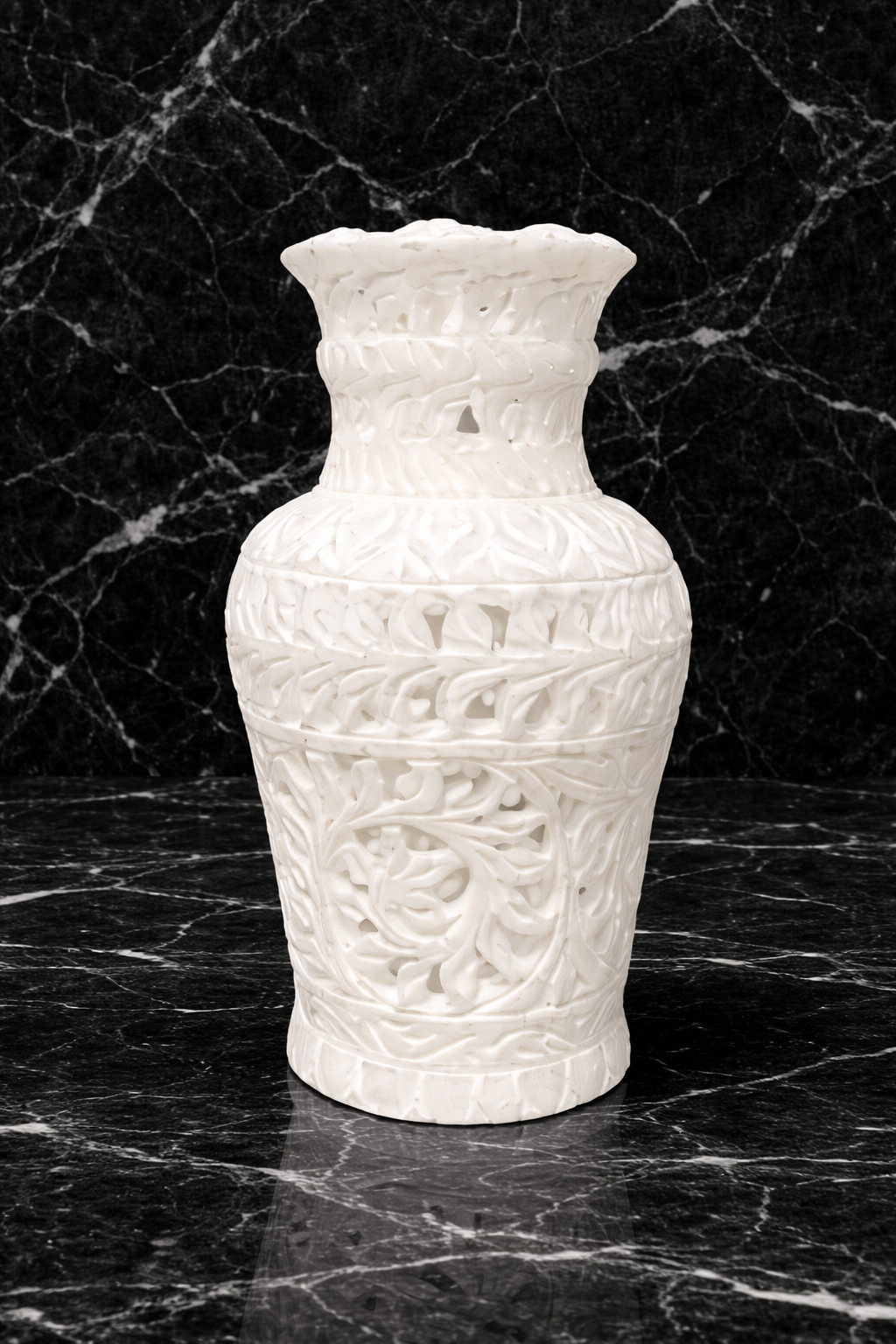 Hand-carved white marble vase on Black marble surface