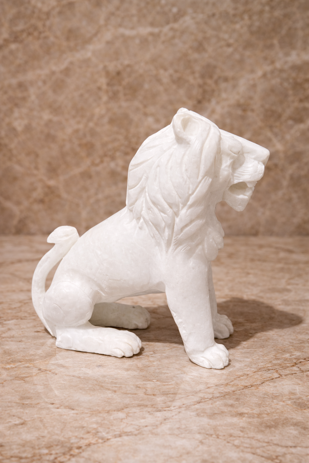 Side view of polished white marble sitting lion sculpture on beige marble surface