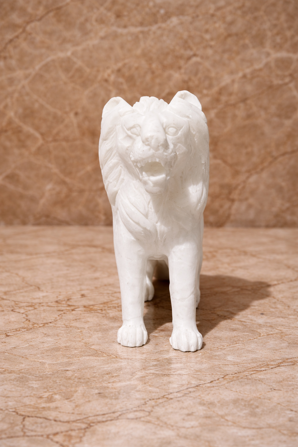 Front view of polished white marble sitting lion sculpture on beige marble surface