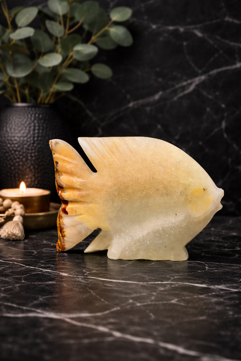 Polished onyx fish stone sculpture with dark luxury background