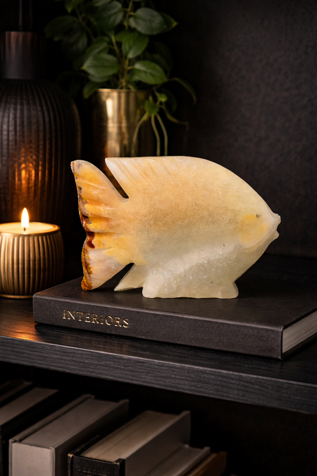 Polished onyx fish stone sculpture 0.336 kg in dark luxury interior setting