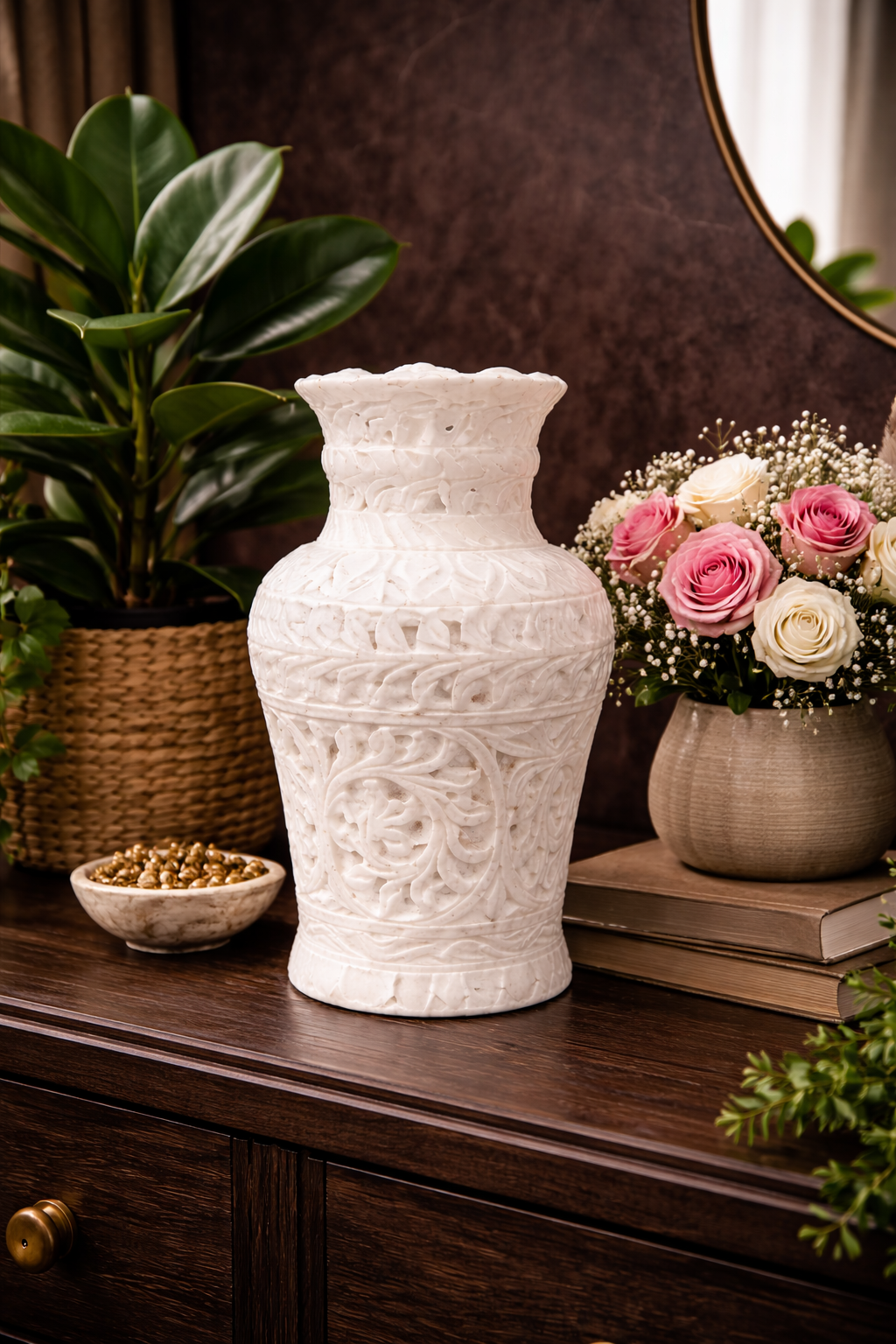 Hand-carved white marble decorative vase on dark wooden console table with candle and books in warm ambient setting