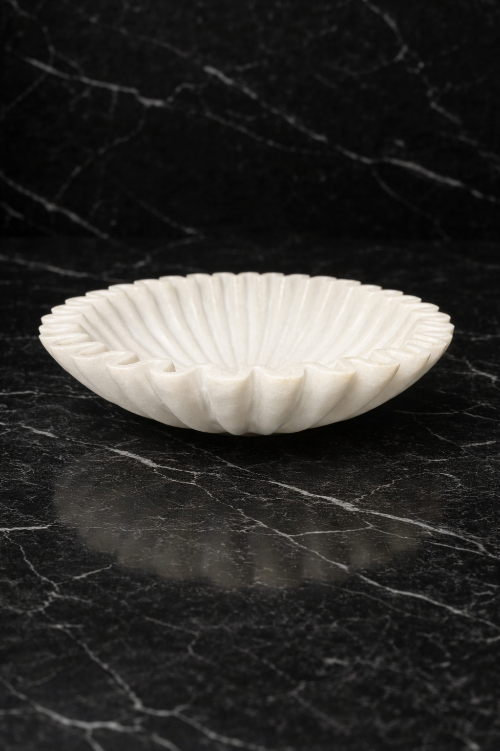Hand-carved white marble zigzag decorative bowl on black marble surface, luxury stone home décor NZ