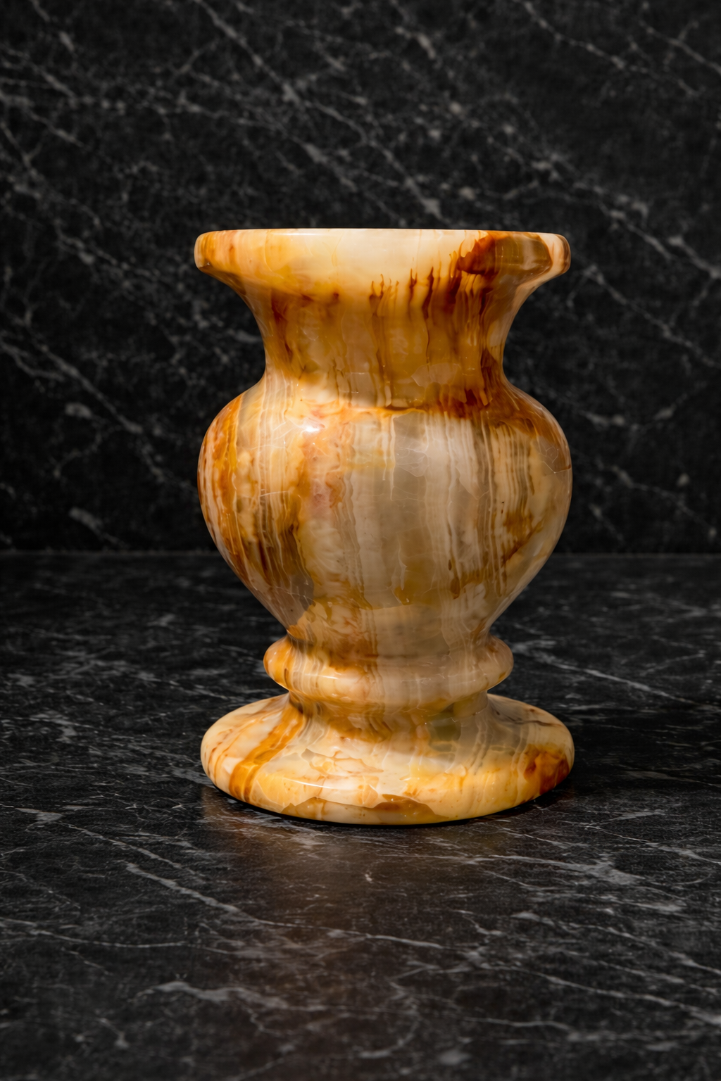 Decorative onyx vase on a dark marble surface