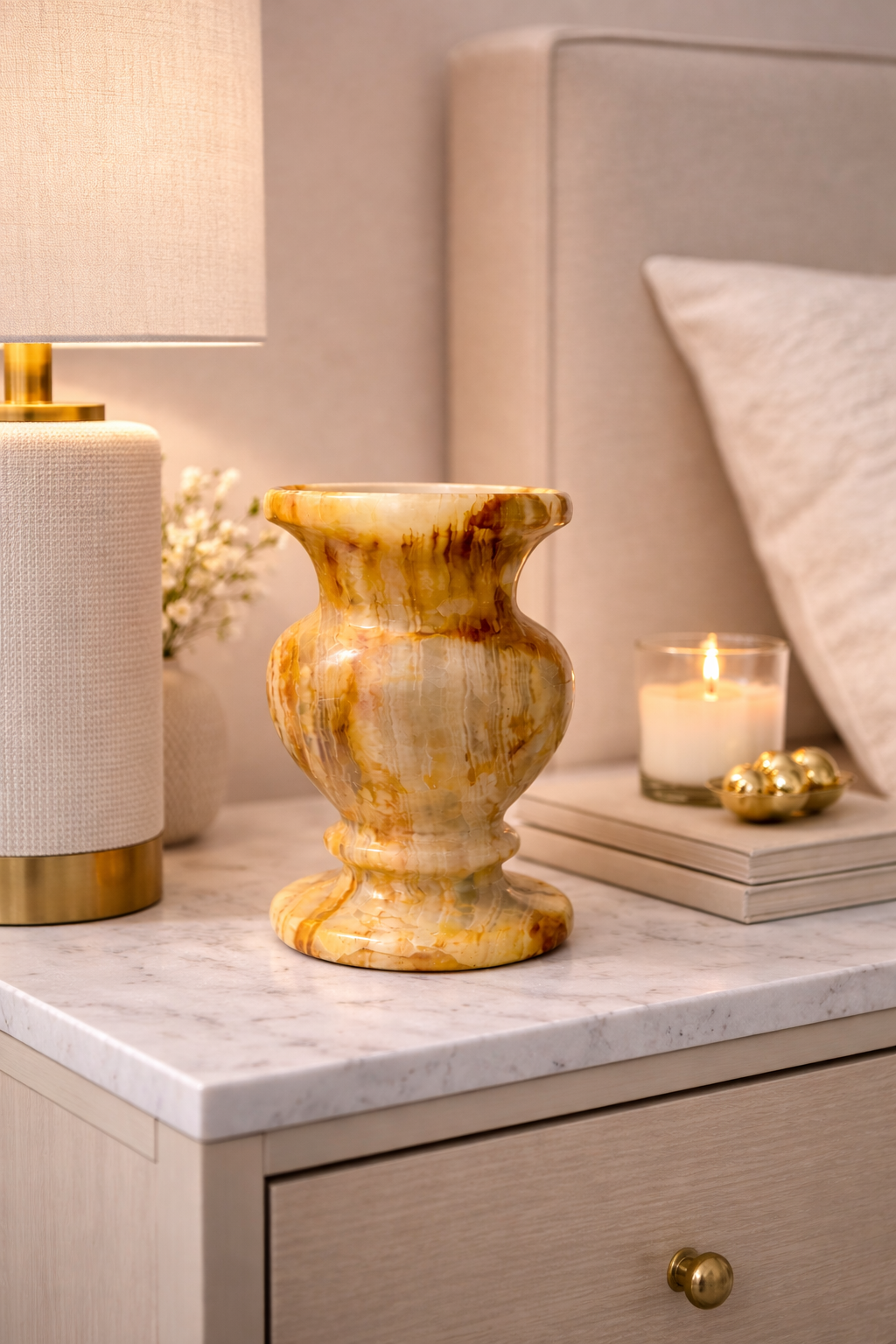 Natural onyx pot on bedside table with candle and lamp, luxury bedroom decor NZ.