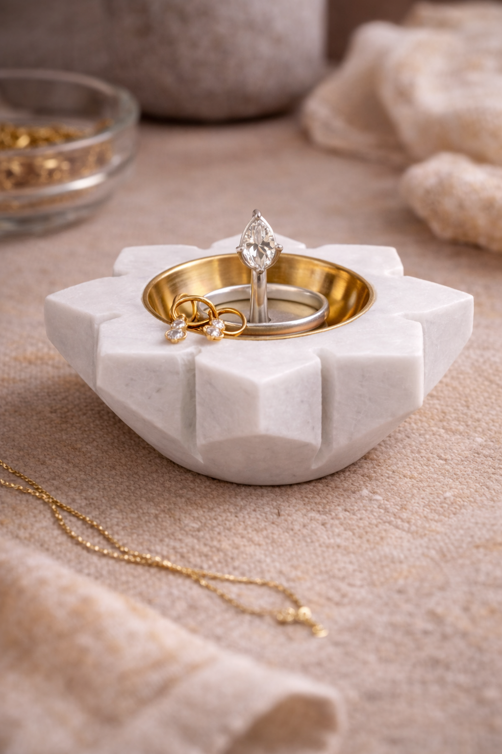 White marble jewellery holder with gold rings and a necklace 