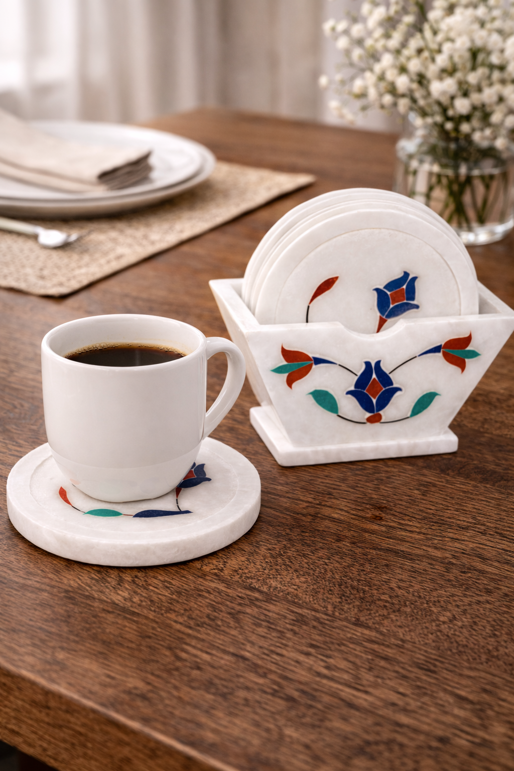 Coffee cup on white marble coaster with floral pietra dura inlay on dining table
