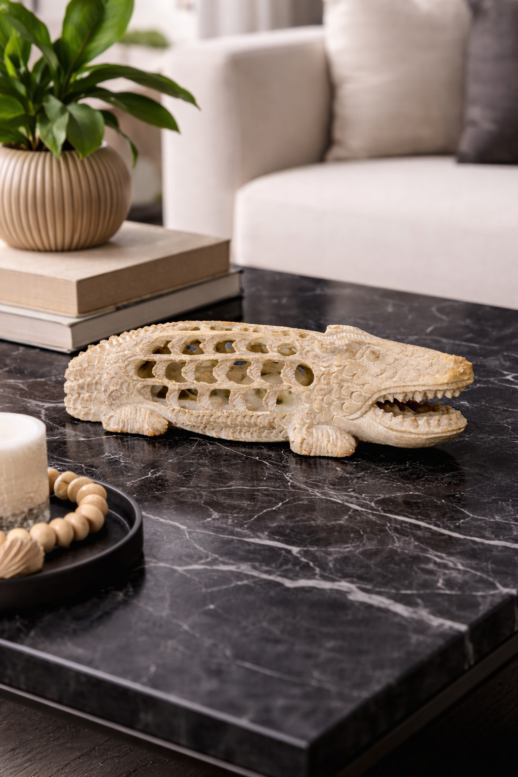 Natural soapstone crocodile sculpture with open lattice detailing in neutral home setting