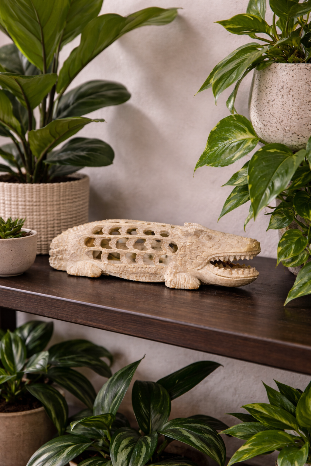 Hand-carved soapstone crocodile figurine styled on dark marble console table with indoor plant in NZ modern home interior