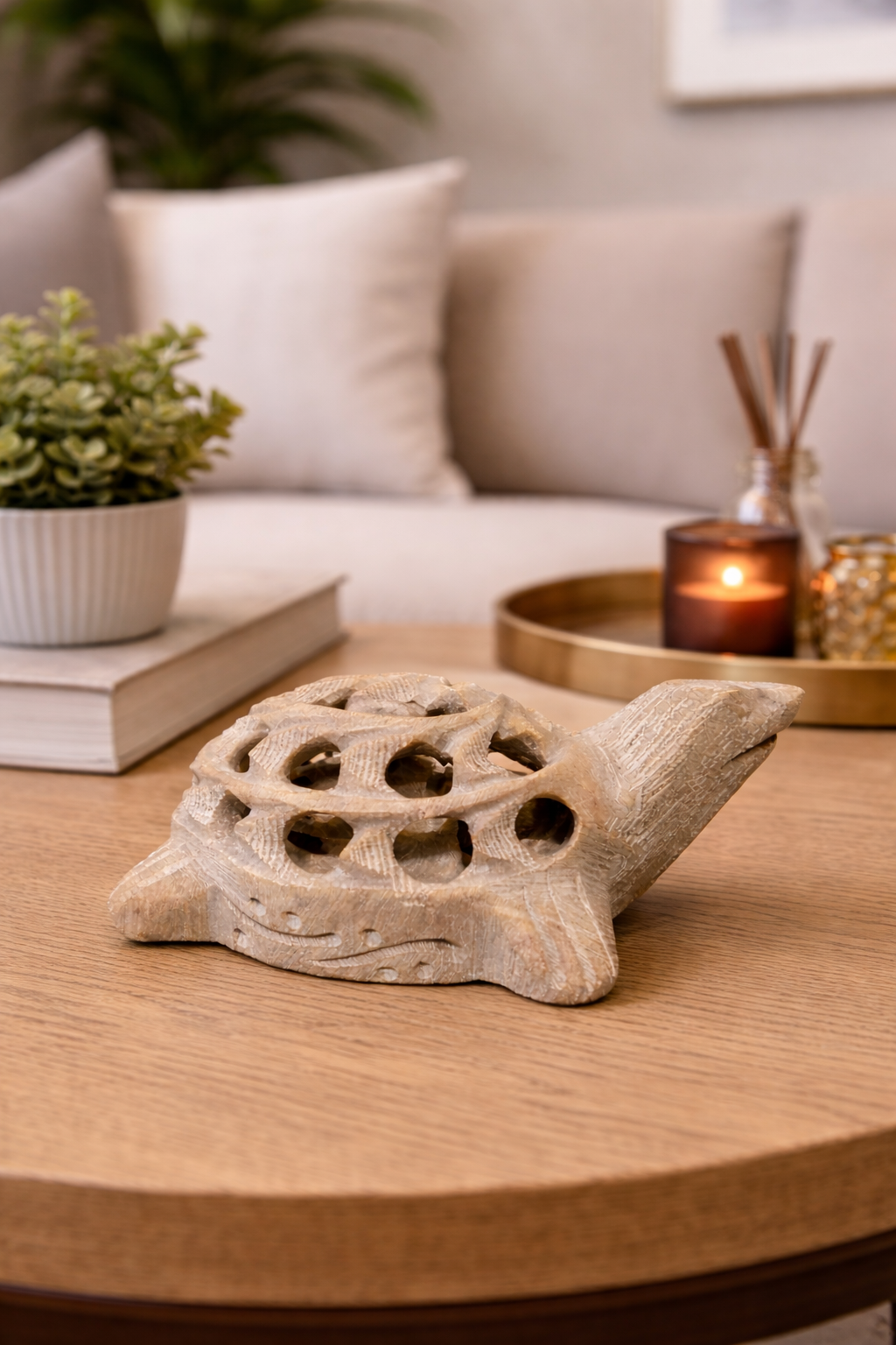 Hand-carved curved soapstone turtle sculpture with open shell design on wooden table