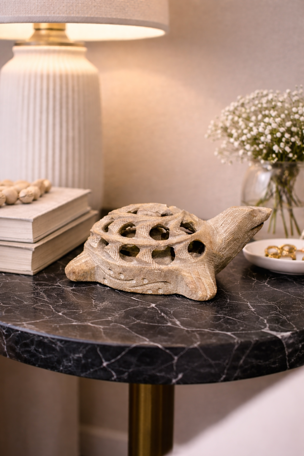 Hand-carved curved soapstone turtle sculpture with open shell design on marble table in NZ home setting