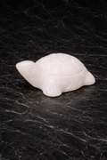 White marble mini turtle figurine with polished finish on black marble surface