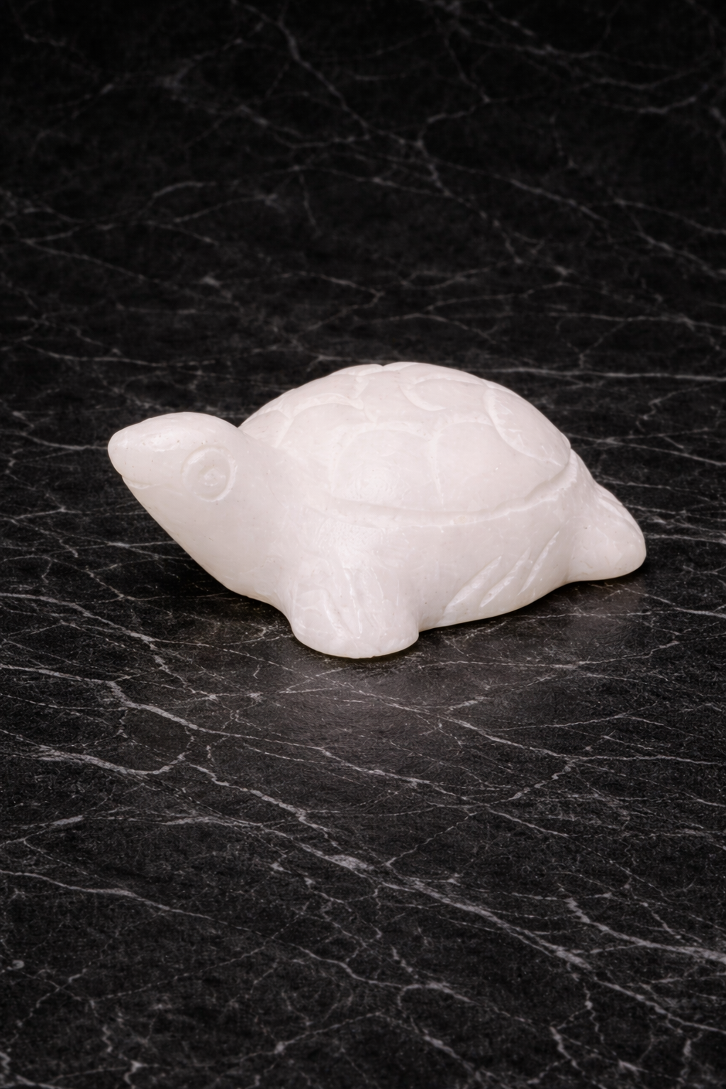 White marble mini turtle figurine with polished finish on black marble surface