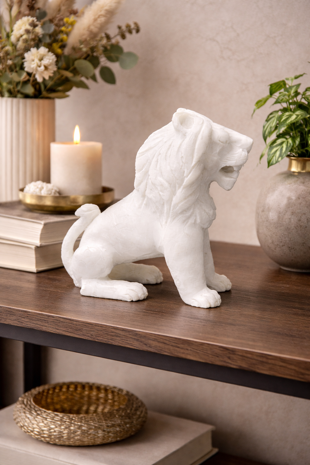 Marble sitting lion sculpture styled on shelf with candlelight and plant backdrop