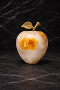 Onyx apple decor with metal leaf stem on a dark marble surface