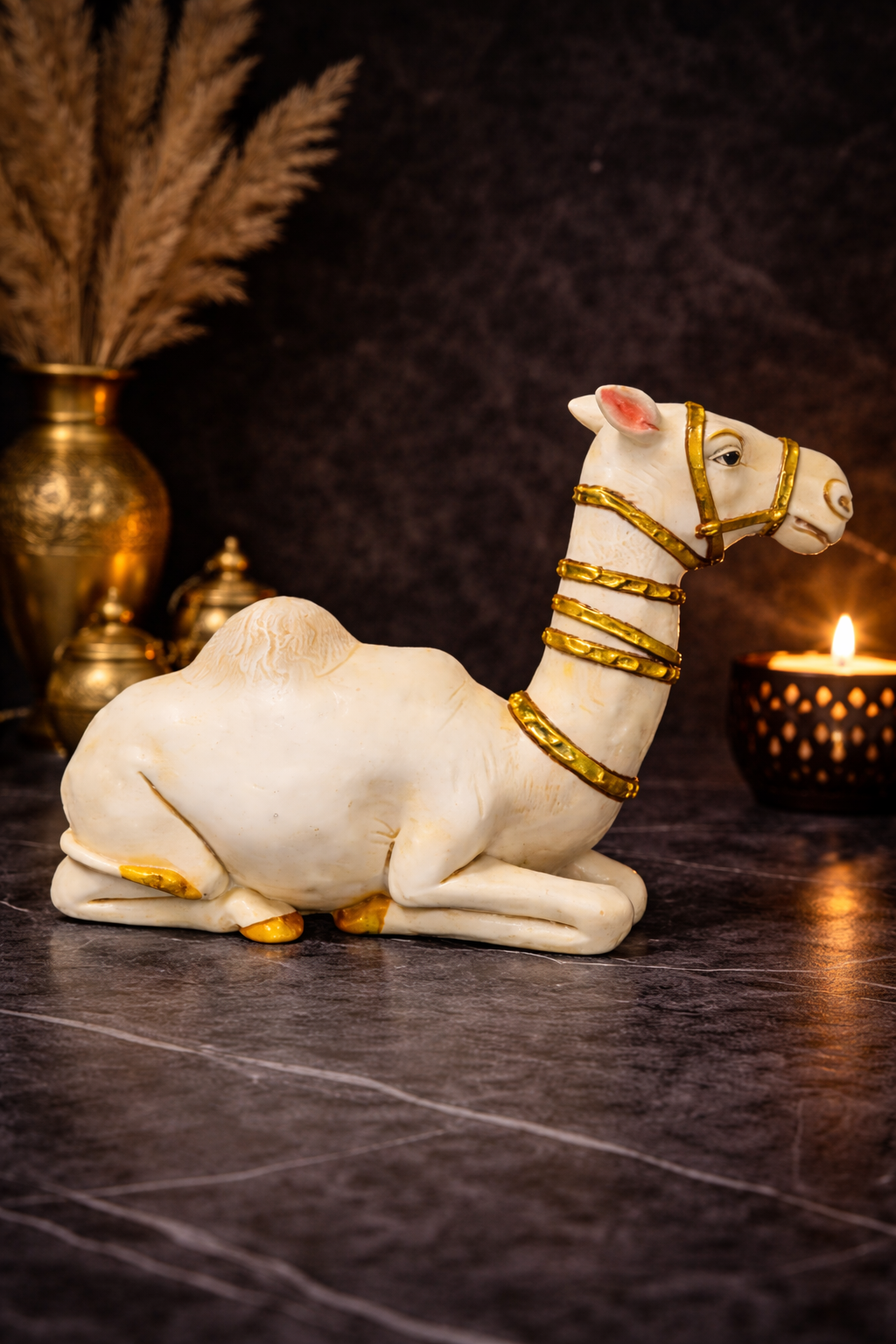 Decorative camel figurine (white and gold) on black marble, side view