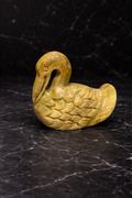 Hand-carved soapstone duck figurine in natural yellow stone on black marble background, small animal décor accent for NZ homes