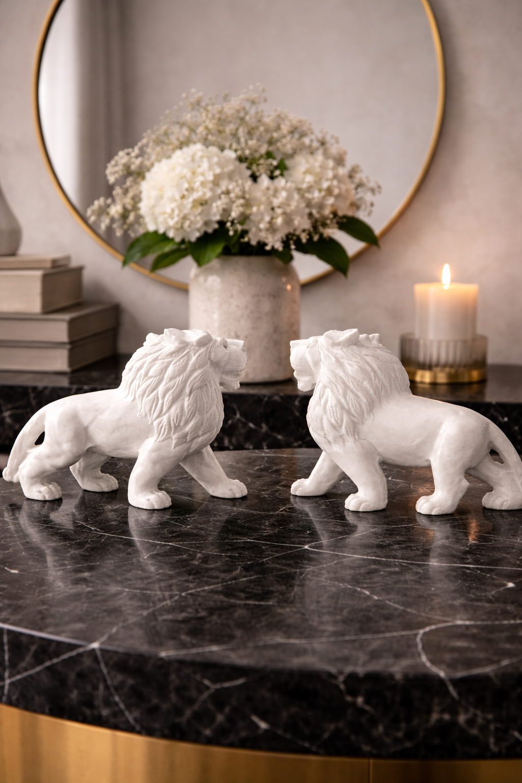 Pair of hand-carved white marble lion sculptures facing each other on marble console table
