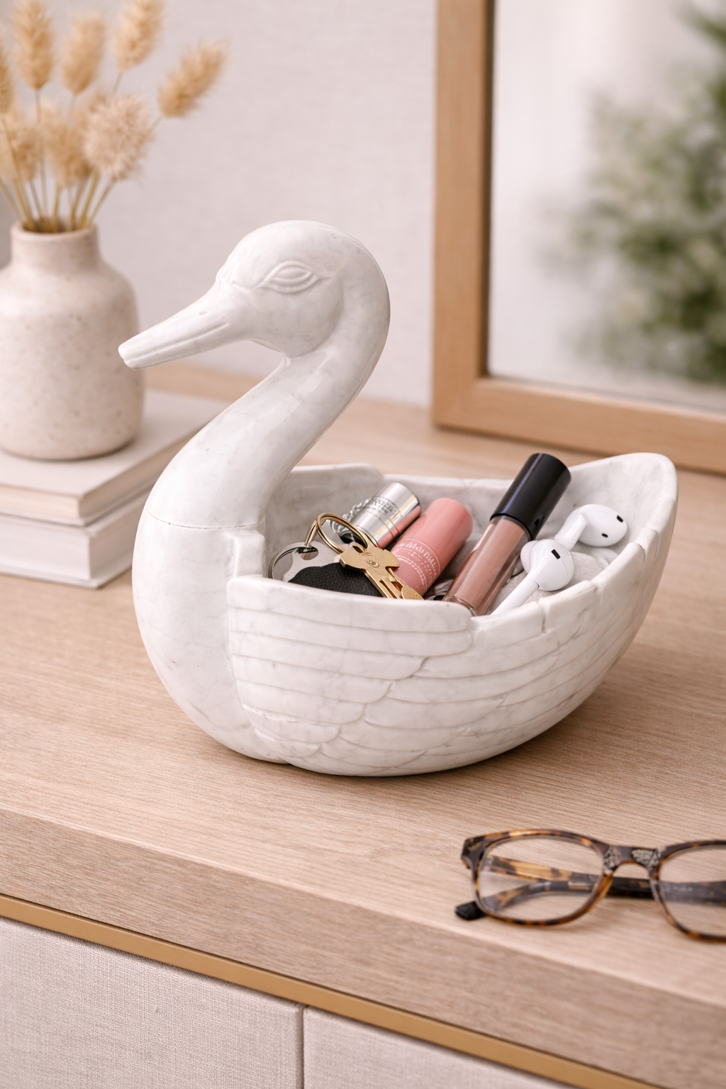 Polished white marble duck-shaped bowl holding makeup and accessories on dressing table, elegant home organiser NZ