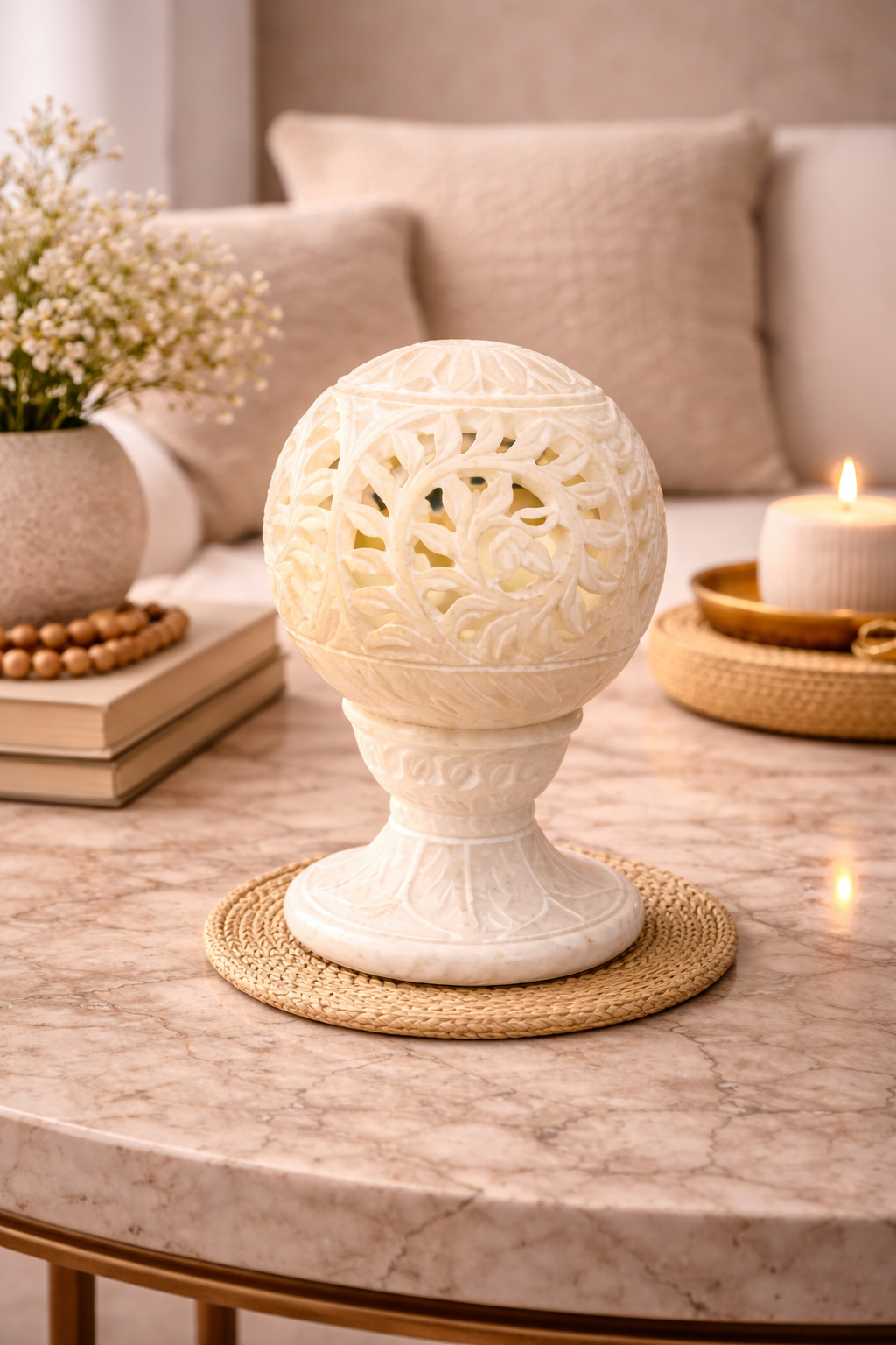 Hand-carved white marble floral tealight holder styled on marble coffee table in elegant living room