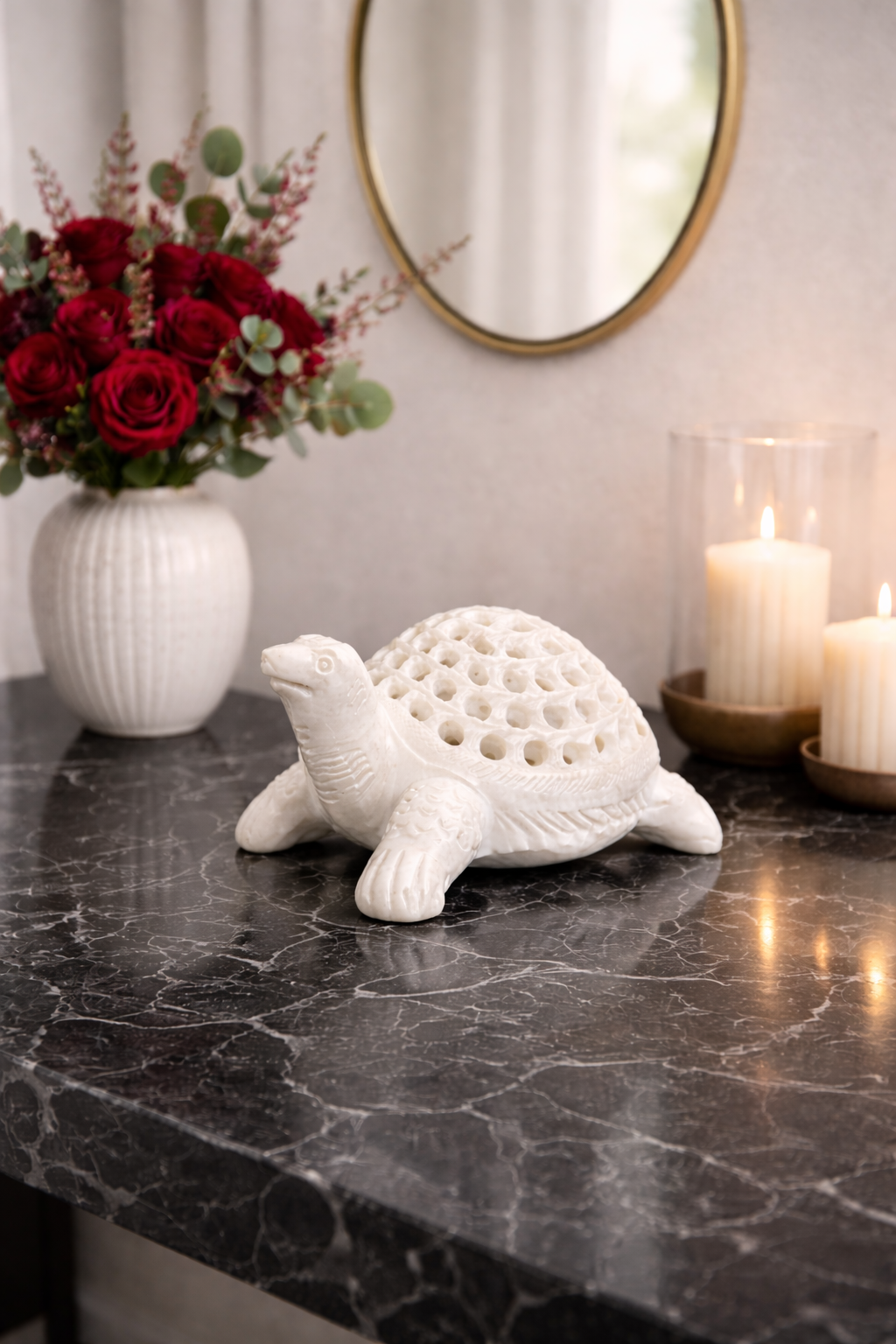 Premium natural marble turtle décor piece styled on marble console table with candles and red roses