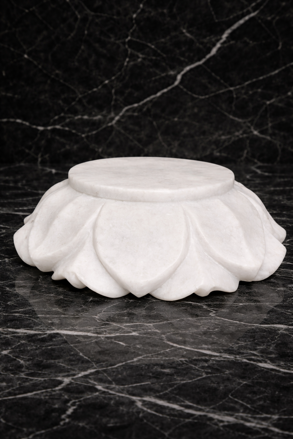 Underside view of handcrafted white marble lotus decorative bowl with carved petal base