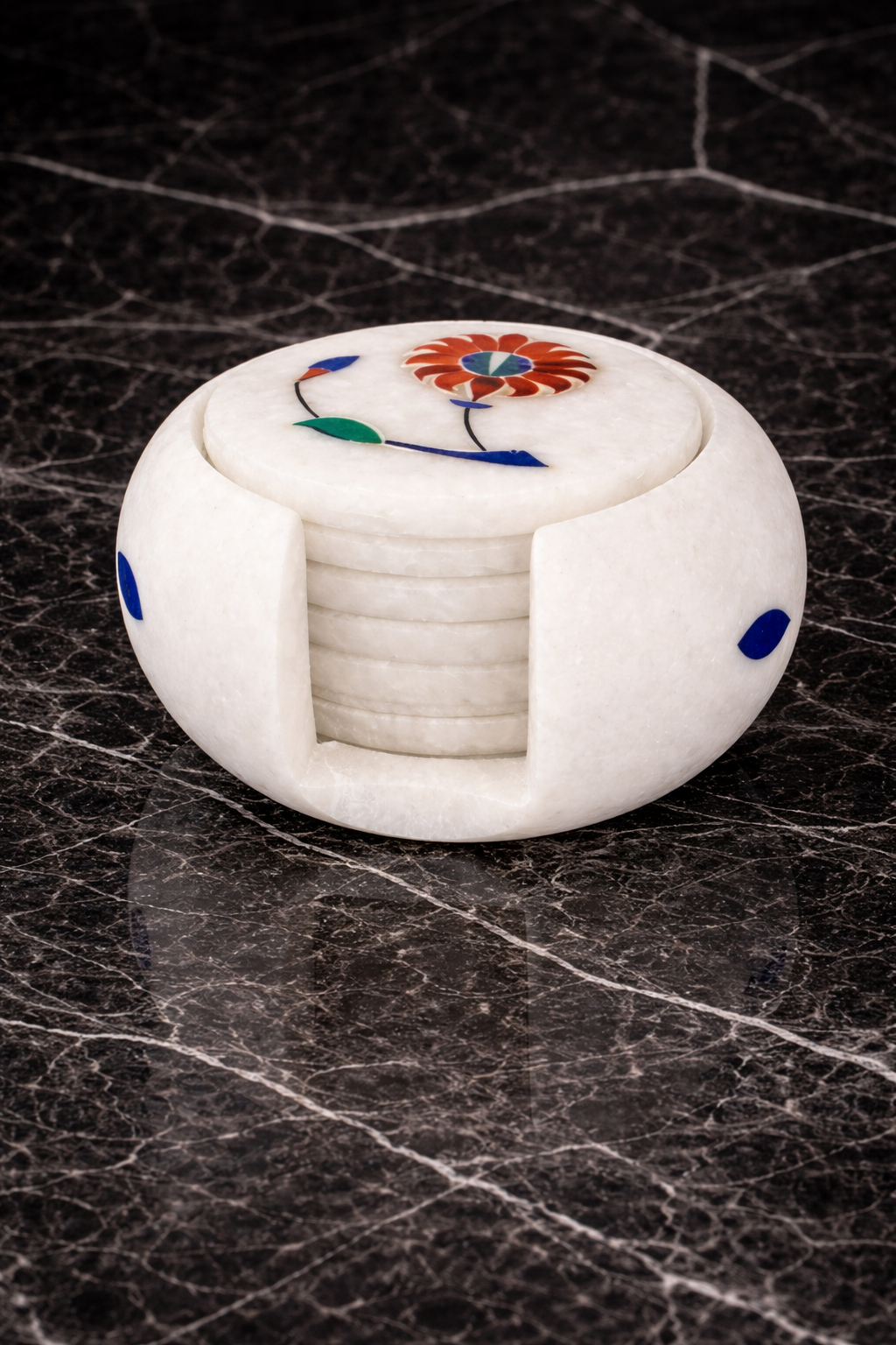 Handcrafted white marble coaster with floral pietra dura inlay design on dark marble table – luxury stone table decor